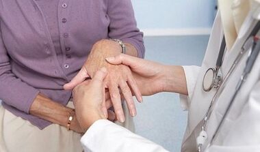 el médico examina las articulaciones de las manos con artrosis y artritis